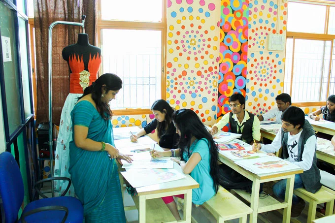 A Picture of Students Writing Notes With A Teacher Guiding Them in One Of Their Fashion Designing Classes At Indian Institute of Fashion Technology